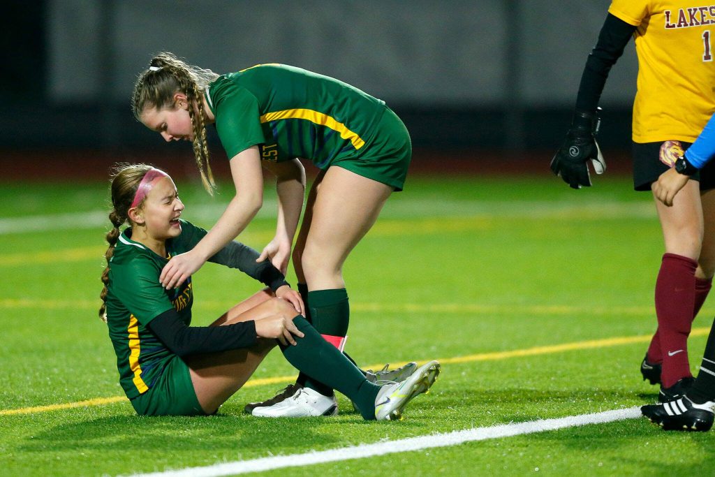 Shorecrest captain Taylor Christensen checks on injured freshman Olivia Taylor against Lakeside during the WIAA 3A Girls Soccer Semifinal on Friday, Nov. 17, 2023, at Carl Sparks Stadium in Puyallup, Washington. (Ryan Berry / The Herald)
