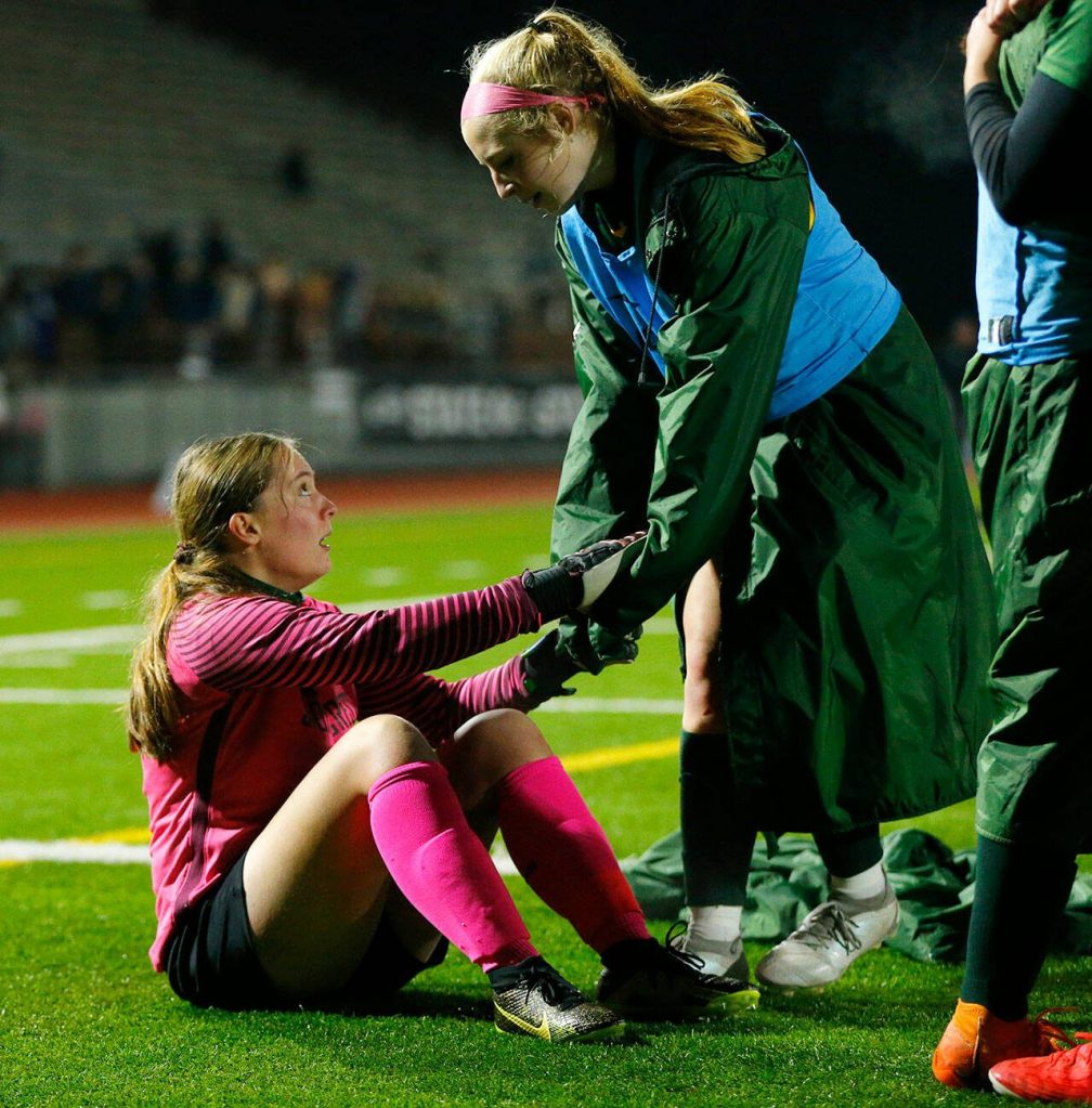 Shorecrest goaltender Tatiana Zahajko is helped back to her feet by a teammate as they team celebrates a victory against Lakeside during the WIAA 3A Girls Soccer Semifinal on Friday, Nov. 17, 2023, at Carl Sparks Stadium in Puyallup, Washington. (Ryan Berry / The Herald)