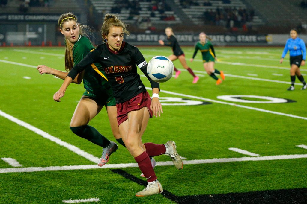 Shorecrest freshman defender Kai Johnson and Lakeside’s Eleanor Morrissey both run after the ball during the WIAA 3A Girls Soccer Semifinal on Friday, Nov. 17, 2023, at Carl Sparks Stadium in Puyallup, Washington. (Ryan Berry / The Herald)