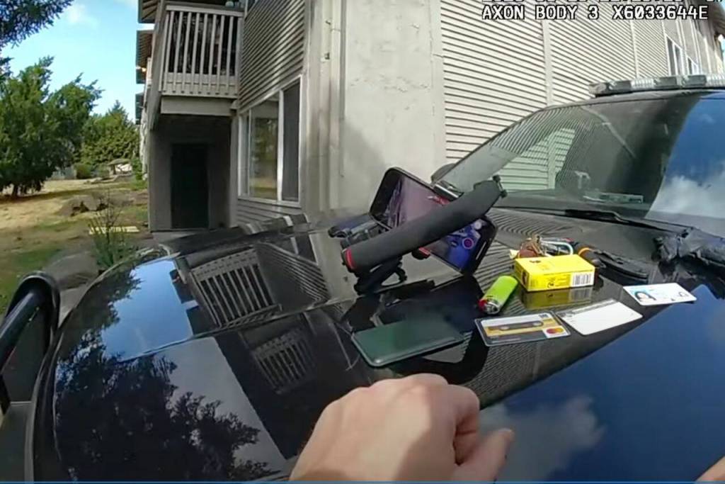 From the bodycam footage of Everett police officer Ryan Greely, Greely lays out Molly Wrights belongings on the hood of his patrol car after arresting her for obstructing a law enforcement officer on Aug. 10, 2023 in Everett, Washington. (Screenshot from a video provided by Molly Wright)