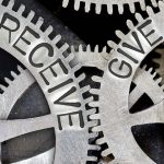 Macro photo of tooth wheel mechanism with imprinted RECEIVE, GIVE concept words