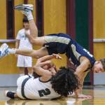 Arlingtons Kaid Hunter tumbles over Jacksons Seamus Williams during the game on Tuesday, Nov. 28, 2023 in Everett, Washington. (Olivia Vanni / The Herald)