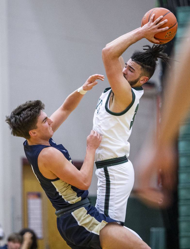 Jacksons Trey Hawkins leaps to get a rebound during the game against Arlington on Tuesday, Nov. 28, 2023 in Everett, Washington. (Olivia Vanni / The Herald)