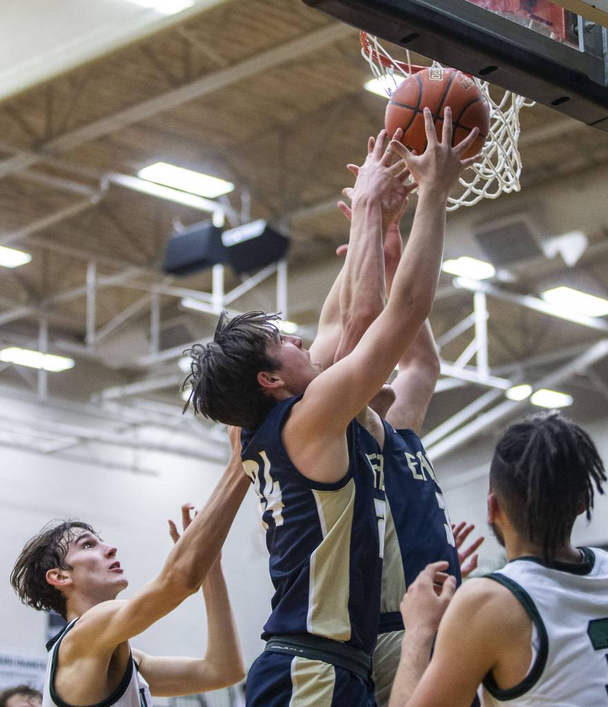Multiple Arlington players leaps in the air for a rebound during the game against Jackson on Tuesday, Nov. 28, 2023 in Everett, Washington. (Olivia Vanni / The Herald)