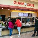 Customers pick up orders at Guam Grub at the Everett Mall in Everett, Washington. Owner Julita Atoigue-Javier said her business has been selling out almost every day since opening. (Ryan Berry / The Herald)