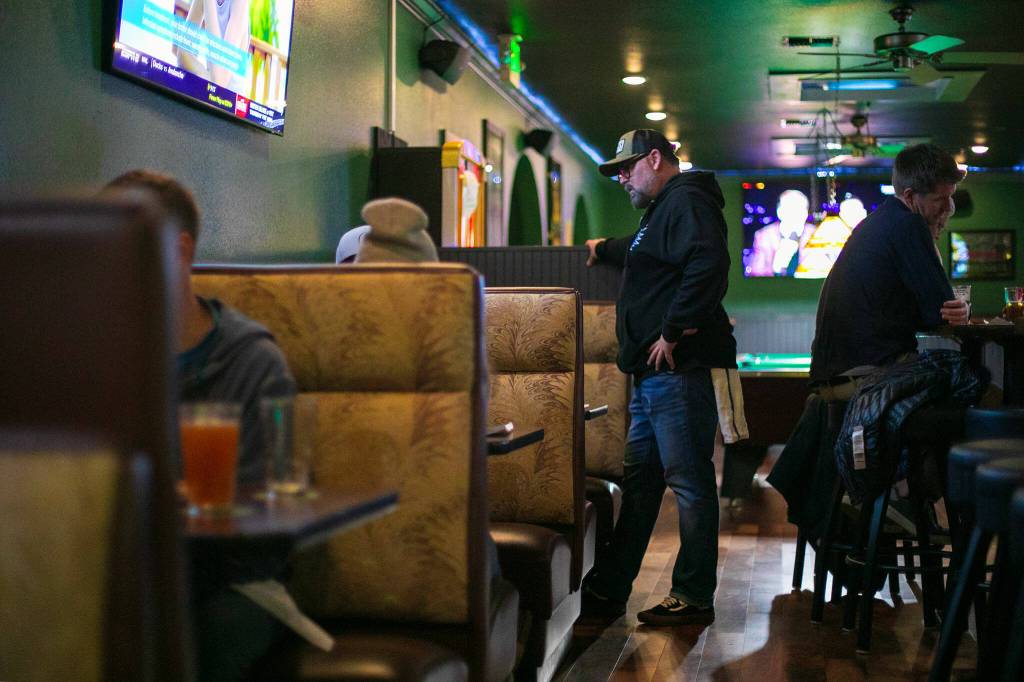 Bartender Hunter Haynes chats with a few customers before taking their order at Coles Tavern in Mukilteo. (Ryan Berry / The Herald)