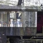 A company name is visible on the side of a derelict boat seen along Union Slough on Tuesday, Nov. 21, 2023 in Everett, Washington. (Olivia Vanni / The Herald)