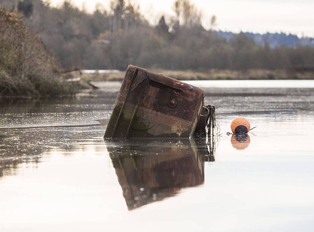 A large metal box floats in Ebey Slough on Tuesday, Nov. 21, 2023 in Everett, Washington. (Olivia Vanni / The Herald)