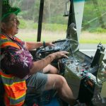 Island Transit driver Tino Gutierrez, a Navy veteran who has been a transit driver for two decades, laughs while talking about his route on Tuesday, Dec. 19, 2023, somewhere outside Oak Harbor, Washington. Gutierrez wears festive getup for holidays year-round as a way to brighten his own life and the life of others. (Ryan Berry / The Herald)