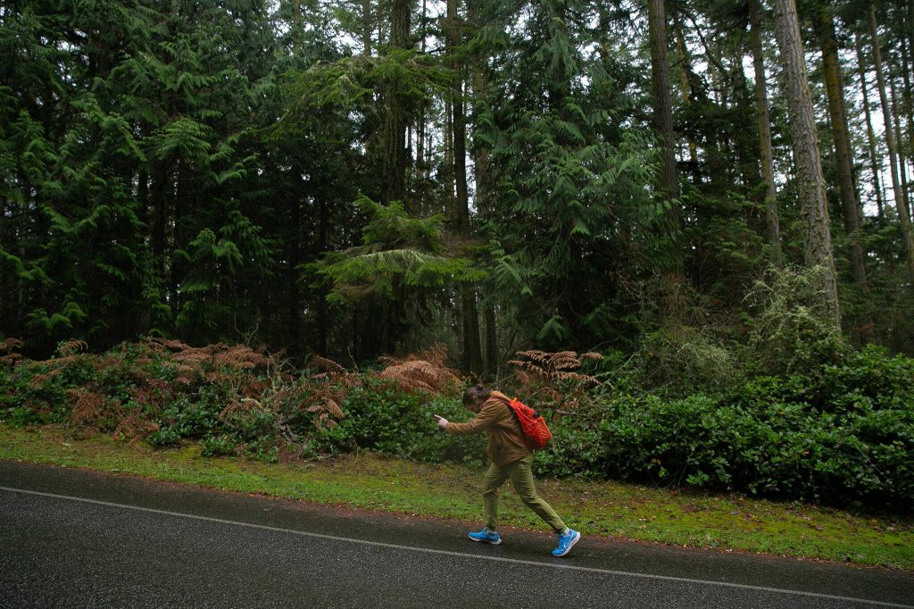 Herald reporter Jordan Hansen hoofs the last mile from Highway 20 to the Salish Sea through Deception Pass State Park on Tuesday, Dec. 19, 2023, in Oak Harbor, Washington. Bus riders can walk from the nearest stop up Highway 20 to the Deception Pass bridge or down into the park and to the shore. (Ryan Berry / The Herald)