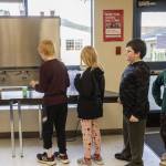 Darrington Elementary School fourth and fifth graders line up to get cups of milk during lunch on Monday, Nov. 20, 2023 in Darrington, Washington. (Olivia Vanni / The Herald)