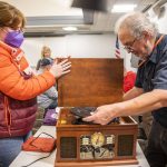 Clark Wood, right, starts repairs on a record player brought in to the Repair Cafe on Saturday, Nov. 18, 2023 in Mountlake Terrace, Washington. (Olivia Vanni / The Herald)