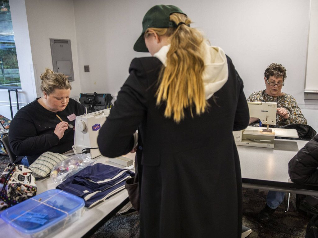 Kelly Leahy, left, and Cindy Parker, right, work on sewing and sticking items brought in for repairs at the Repair Cafe on Saturday, Nov. 18, 2023 in Mountlake Terrace, Washington. (Olivia Vanni / The Herald)