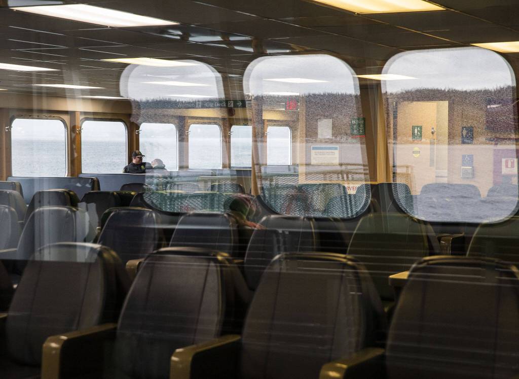People people sit inside the M/V Kitsap on Friday, Dec. 1, 2023 in Mukilteo, Washington. (Olivia Vanni / The Herald)