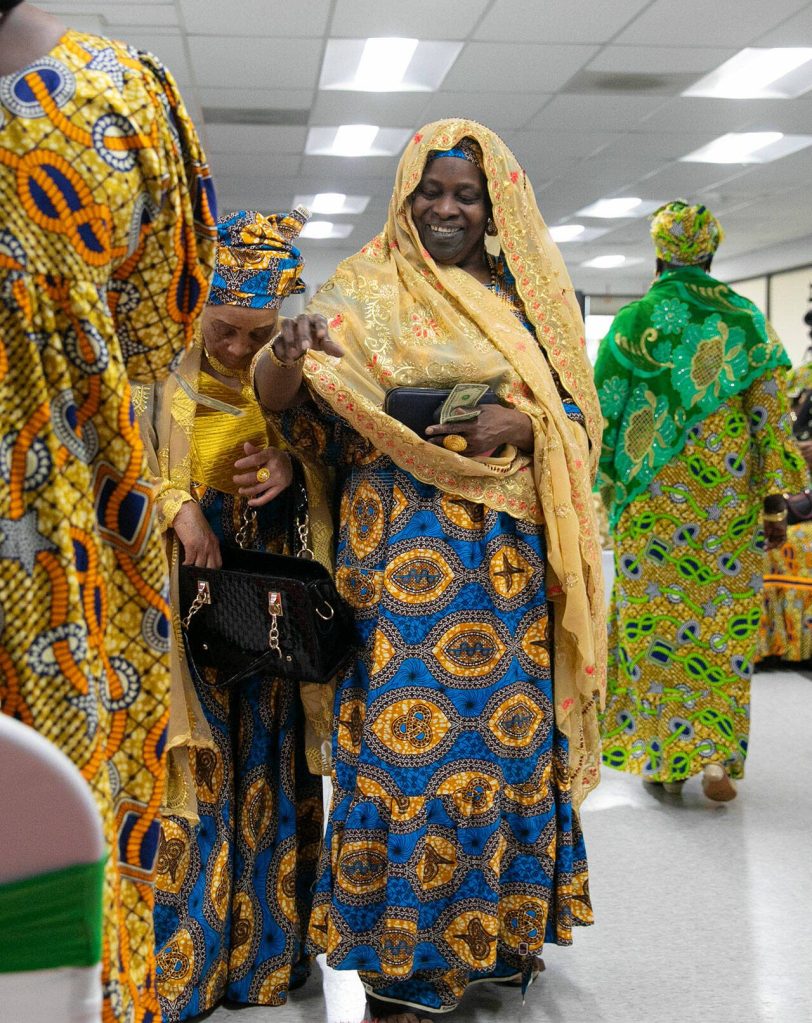 Grandmas take turns donating money during a song at the grand opening of the Washington West African Center on Saturday, Dec. 2, 2023, in Lynnwood, Washington. (Ryan Berry / The Herald)