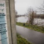 A sign showing the river levels of previous floods is visible along the Snohomish River on Monday, Dec. 4, 2023 in Snohomish, Washington. (Olivia Vanni / The Herald)