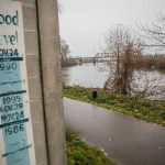 A sign showing the river levels of previous floods is visible along the Snohomish River on Monday, Dec. 4, 2023 in Snohomish, Washington. (Olivia Vanni / The Herald)