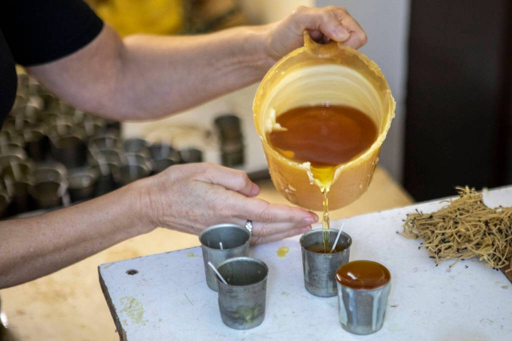 Katherine Hopke pours candles for her business Golden Light Beeswax Candles at her home in Everett, Washington on Thursday, Nov. 30, 2023. (Annie Barker / The Herald)
