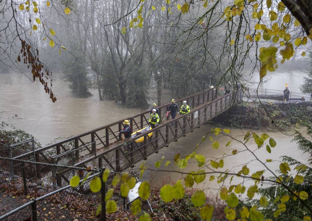Snohomish Regional Fire and Rescue crews leave Al Borlin Park after rescuing three stranded people on Tuesday, Dec. 5, 2023 in Monroe, Washington. (Olivia Vanni / The Herald)