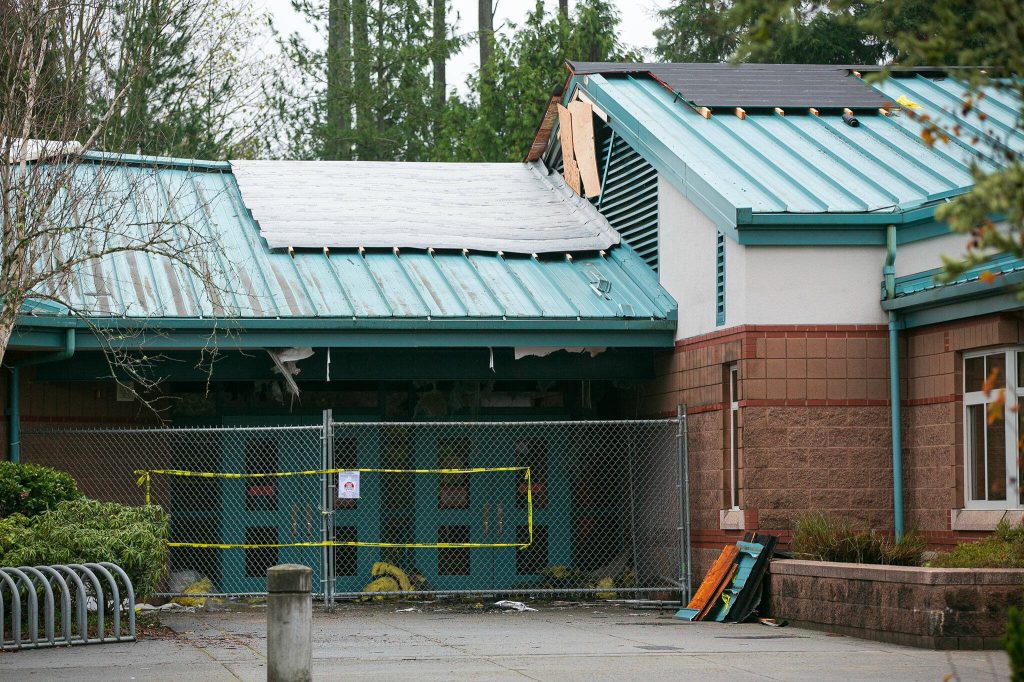 An entrance to Endeavour Elementary School is fenced off, and spots of damage are visible on Wednesday, Dec. 6, 2023, two days after an overnight fire inside the school in Mukilteo, Washington. (Ryan Berry / The Herald)