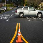 A car drives over newly marked bike lanes at the intersection of College Avenue and 47th Street SE on Friday, Dec. 8, 2023 in Everett, Washington. (Olivia Vanni / The Herald)