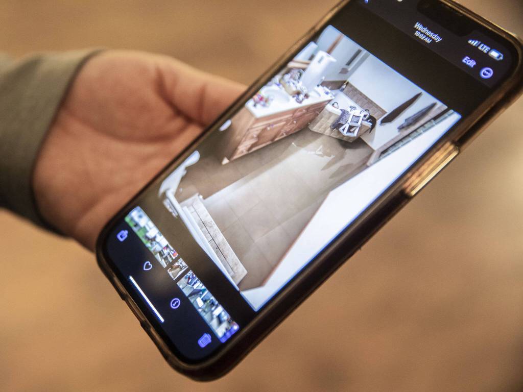 Dannika Prime shows a photograph of the standing water inside her bathroom on Tuesday, Dec. 12, 2023 in Silvana, Washington. (Olivia Vanni / The Herald)