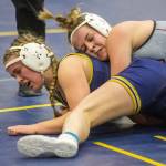 An Everett wrestler grimaces after a Cascade wrestler throws them to the mat on Wednesday, Dec. 13, 2023 in Everett, Washington. (Olivia Vanni / The Herald)