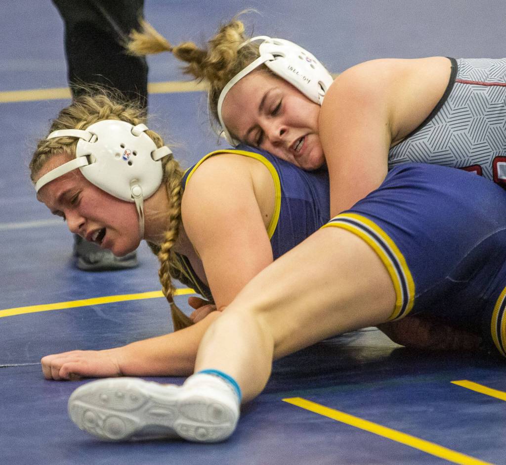 An Everett wrestler grimaces after a Cascade wrestler throws them to the mat on Wednesday, Dec. 13, 2023 in Everett, Washington. (Olivia Vanni / The Herald)
