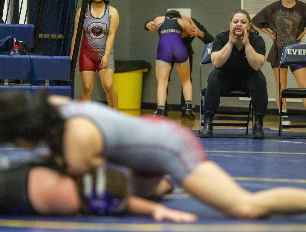 A Kamiak coach yell instructions to her wrestler on Wednesday, Dec. 13, 2023 in Everett, Washington. (Olivia Vanni / The Herald)