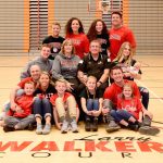 Former Everett Community College basketball coach Larry Walker (middle row, second to right) poses with his family, including grandson and current Trojans mens basketball player Ethan Martin (middle row, left) on the court that bears his name. (Everett Community College photo)