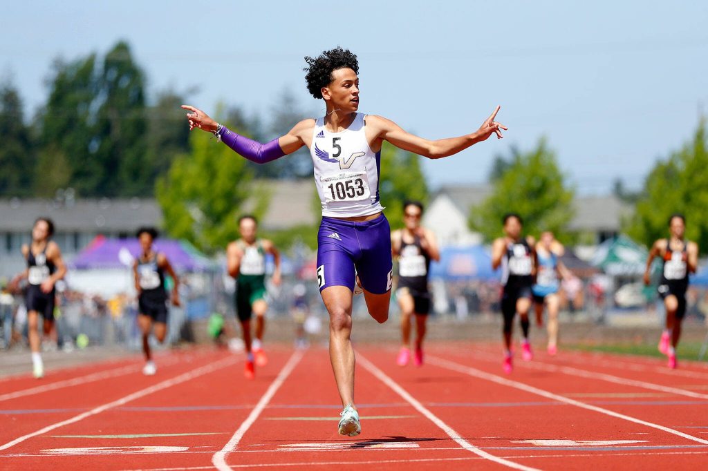 Lake Stevens runner Grant Buckmiller, a senior, throws his hands up as he wins the 4A boys 400-meter dash by more than three seconds during the WIAA State Track and Field Championships on Saturday, May 27, 2023, at Mount Tahoma High School in Tacoma, Washington. (Ryan Berry / The Herald)
