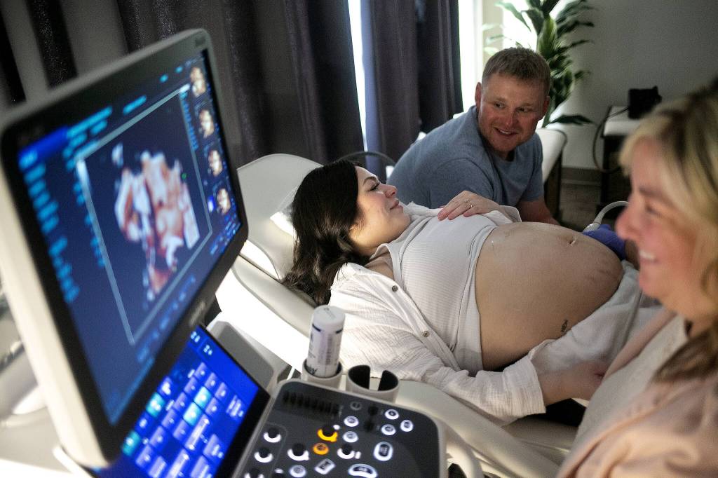 Spouses Franchesca and Don Simpson talk about their baby girl's "chubby cheeks" and "button nose" as Kelly Fox RDMS RVT performs a live-view 3D ultrasound on the expecting mother Saturday, August 26, 2023, at Wonder Baby Ultrasound Studio in Everett, Washington. (Ryan Berry / The Herald)