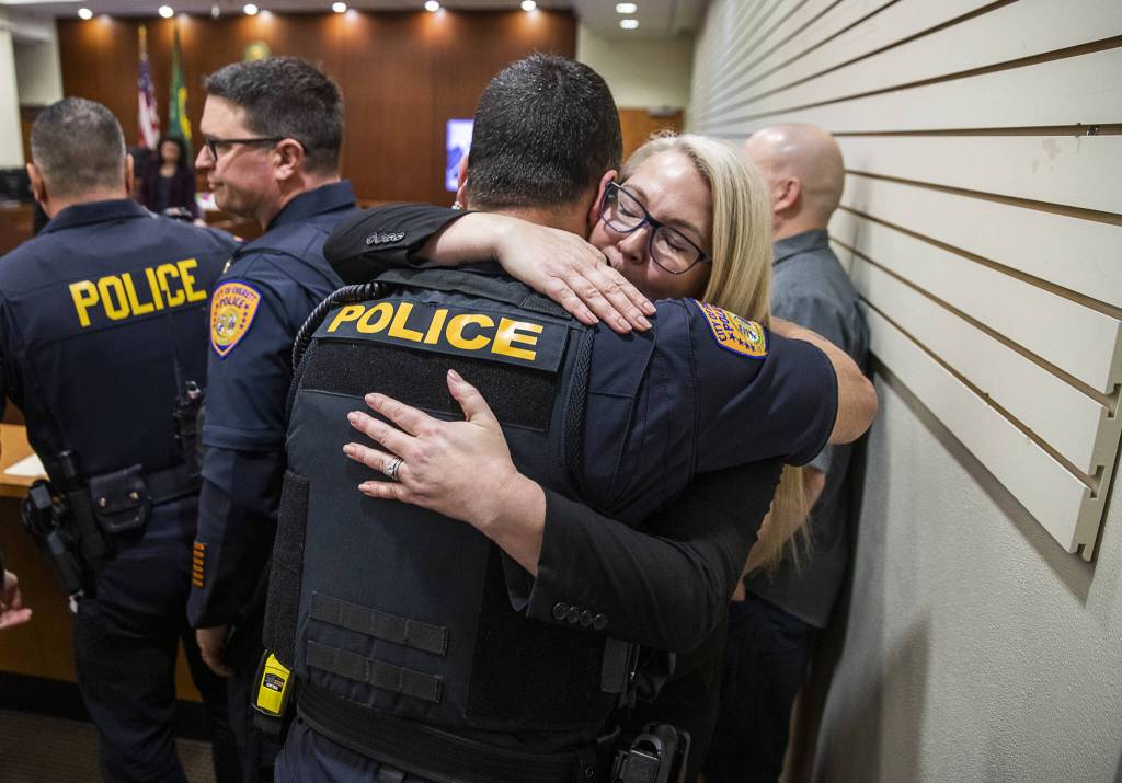Snohomish County Sheriffs Office detective Kendra Conley, right, hugs Everett police Lt. Tim Collings, left, after the reading of the verdict at the trial of Richard Rotter at the Snohomish County Courthouse on Monday, April 3, 2023, in Everett, Washington. Rotter, who murdered Everett police officer Dan Rocha in March 2022, was sentenced to life in prison without the possibility of parole. (Olivia Vanni / The Herald)