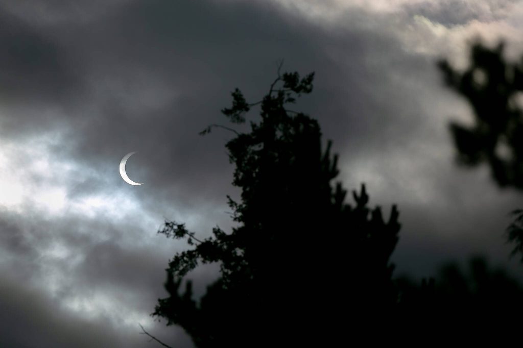 Ryan Berry / The Herald
Clouds pass in front of the moon and sun as the two cross paths during an annular eclipse seen from Everett on Oct. 14. A total eclipse will be visible over parts of the United States in April.