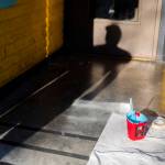 Reed casts a shadow int he entry to the Catalyst Cafe while painting the exterior on Thursday, Dec. 21, 2023 in Everett, Washington. (Olivia Vanni / The Herald)