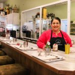 Megan Varner-Duckett, owner of Varner Candle Company, stands behind the bar where guests can enjoy a drink and craft their own candles. (Photo by Luisa Loi)