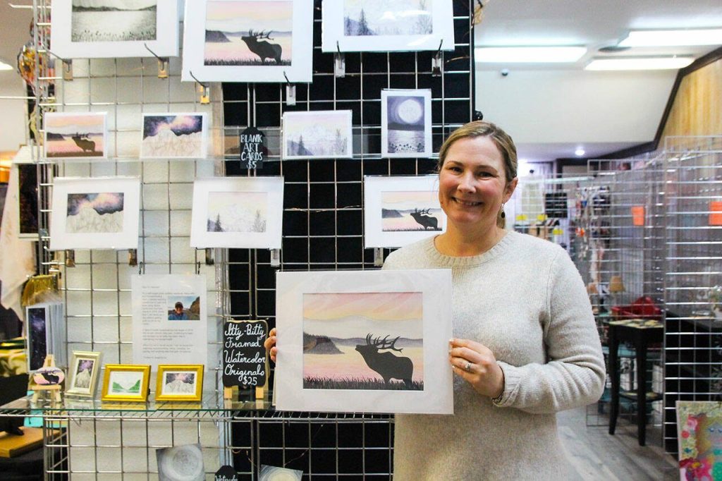 Hannah Sewell holds her art piece dedicated to Bruiser, Whidbeys lone elk. Sewell is one of the artists showcased at Whidbey Island Crafters Market Studios. (Photo by Luisa Loi)
