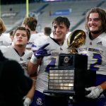 Lake Stevens players take photos with the championship trophy after their win over Graham-Kapowsin during the Class 4A Football state championship game on Dec. 2, 2023, at Husky Stadium in Seattle. (Ryan Berry / The Herald)