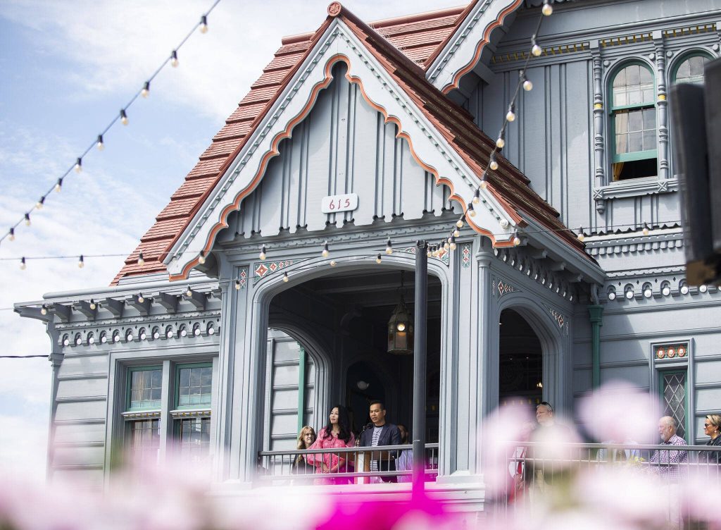 Jack and Jin Ng welcome people to the grand opening of the Muse Whiskey & Coffee Bar in the 100-year-old Weyerhaeuser building on Wednesday, July 12, 2023 in Everett, Washington. (Olivia Vanni / The Herald)