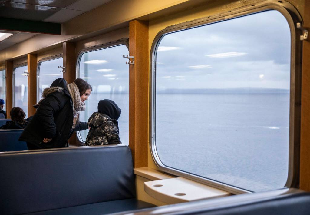 People look out the window from inside the M/V Kitsap on Friday, Dec. 1, 2023 in Mukilteo, Washington. (Olivia Vanni / The Herald)