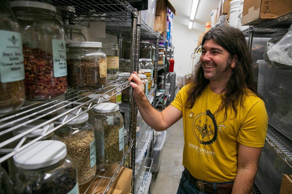 Jeremy Kyncl, co-owner Hierophant Meadery, looks through the variety of herbs and flavoring agents that the meadery uses to create their product on Wednesday, Oct. 4, 2023, in Freeland, Washington. Kyncl and his wife Michelle Scandalis source herbs, mushrooms and fruits locally when possible, sometimes even picking plants from the woods adjacent to their property. (Ryan Berry / The Herald)