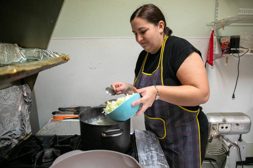 Ivanna Tomashevska slowly adds cabbage to a pot of borscht. Tomashevaska, a native of Ukraine, moved to Washington with her husband and two daughters in 2023 after living in Poland for three years. (Ryan Berry / The Herald)