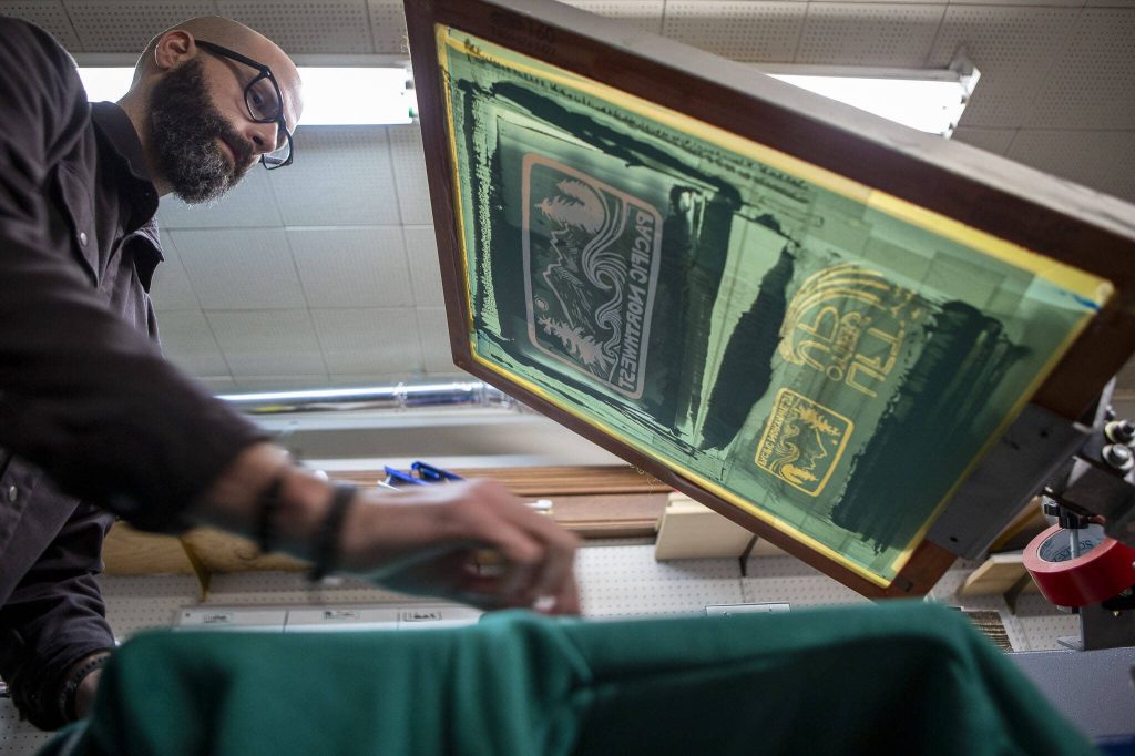 Jonathan Carpenter Eells prints a shirt at elSage in Mount Vernon, Washington, on Thursday, Dec. 14, 2023. (Annie Barker / The Herald)