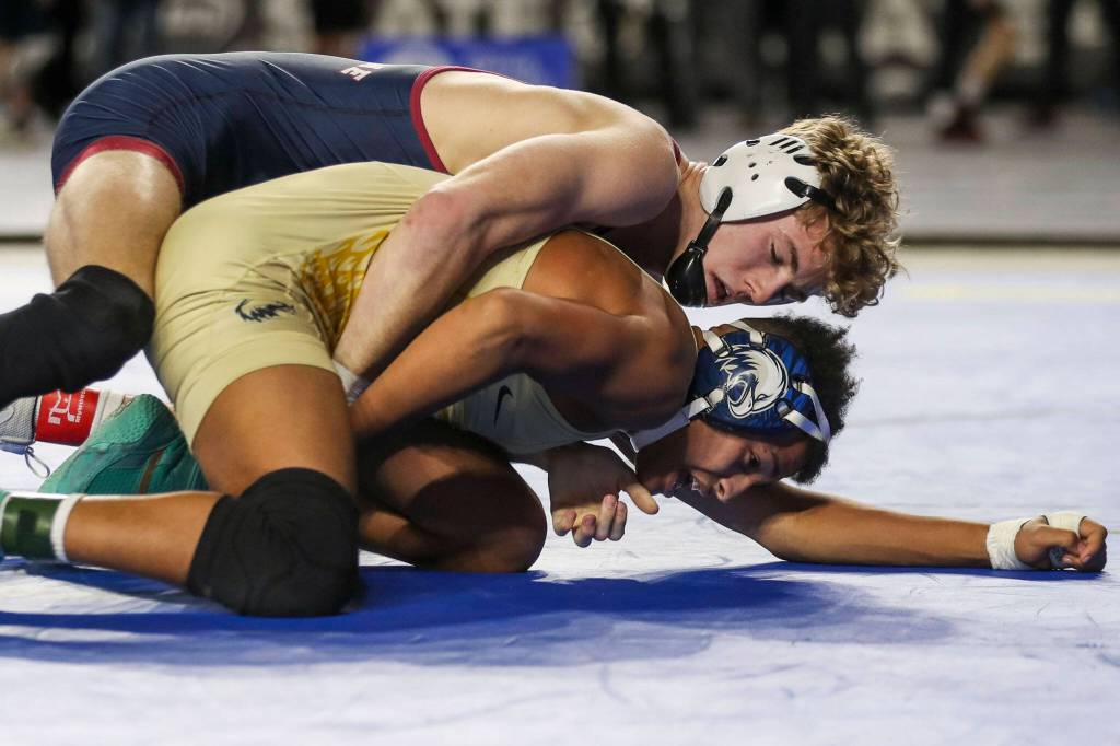 Arlingtons Tre Haines (bottom) wrestles Mount Spokanes Hudson Buth during the 3A boys 138-pound championship match during Mat Classic XXXIV at the Tacoma Dome on Feb. 18, 2023, in Tacoma. (Annie Barker / The Herald)