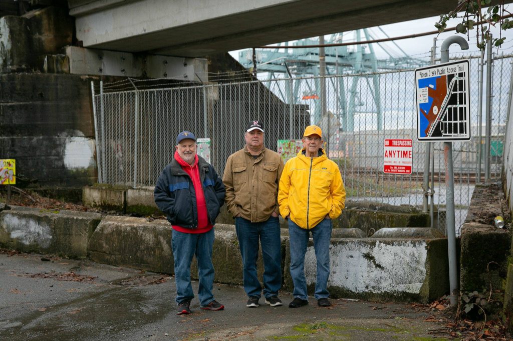 From left, local history buffs Jack ODonnell, Neil Anderson and Larry ODonnell at the now fenced-off Bond Street underpass on Friday, Jan. 19, 2024, in the Port Gardner neighborhood of Everett, Washington. (Ryan Berry / The Herald)