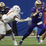 Washington quarterback Michael Penix Jr. (9) scrambles with the ball against Texas defensive end Justice Finkley (1) during the second half of the Sugar Bowl CFP NCAA semifinal college football game, Monday, Jan. 1, 2024, in New Orleans. (AP Photo/Gerald Herbert)