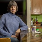 Cindy Clark, a Long-COVID patient, poses for a photo in her home with the various treatments she used in Mukilteo, Washington on Wednesday, Jan. 3, 2024. (Annie Barker / The Herald)
