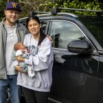 Jake Hitchner, left, and Caitlin Hitchner, right, pose for a photo with their son Boston, eight-days-old, at their home in Edmonds, Washington on Sunday, Jan. 7, 2024. (Annie Barker / The Herald)