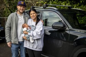 Jake Hitchner, left, and Caitlin Hitchner, right, pose for a photo with their son Boston, eight-days-old, at their home in Edmonds, Washington on Sunday, Jan. 7, 2024. (Annie Barker / The Herald)