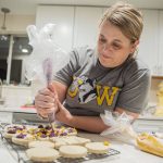 Andrea Ancich frosts University of Washington themed cookies at her Marysville home for her flight to the College Football Playoff National Championship in Texas. (Olivia Vanni / The Herald)